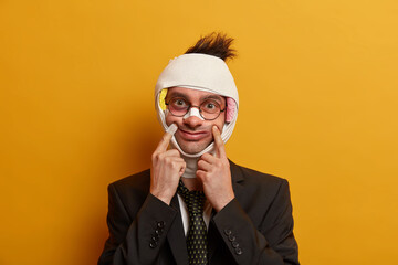 Funny man keeps fingers near corners of lips, pretends smiling, got hematoma after falling bike,...