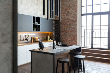luxury studio apartment with a free layout in a loft style in dark colors. Stylish modern kitchen area with an island, cozy bedroom area with fireplace and personal gym