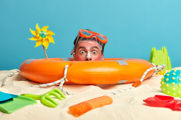 Shocked man realizes he has damaged skin from sun, got sunburn and redness of skin, poses over...