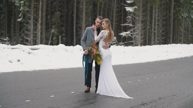 young couple walking on a road in the forest