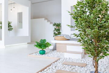 Luxury fashionable modern design studio apartment with a free layout in a minimal style. very bright huge spacious room with white walls and wooden elements. sitting area with fireplace