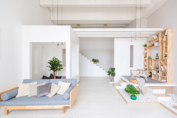 Luxury fashionable modern design studio apartment with a free layout in a minimal style. very bright huge spacious room with white walls and wooden elements. sitting area with fireplace