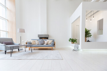 Luxury fashionable modern design studio apartment with a free layout in a minimal style. very bright huge spacious room with white walls and wooden elements. sitting area with fireplace