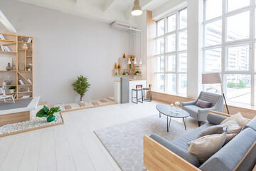 Luxury fashionable modern design studio apartment with a free layout in a minimal style. very bright huge spacious room with white walls and wooden elements. sitting area with fireplace