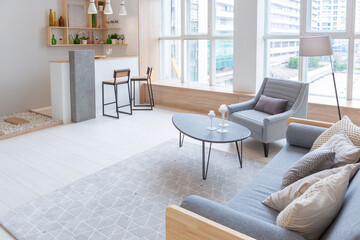 Luxury fashionable modern design studio apartment with a free layout in a minimal style. very bright huge spacious room with white walls and wooden elements. sitting area with fireplace