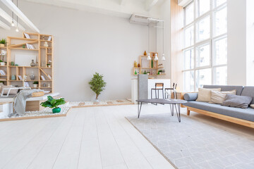 Luxury fashionable modern design studio apartment with a free layout in a minimal style. very bright huge spacious room with white walls and wooden elements. sitting area with fireplace