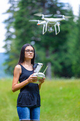 Teenage girl controlling drone with remote control in summer