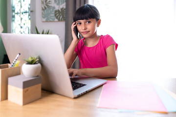 daughter imitating mom telecommuting with cellphone and computer