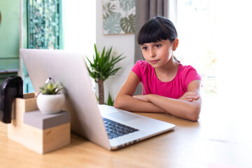 girl at home on a computer and attending a virtual class