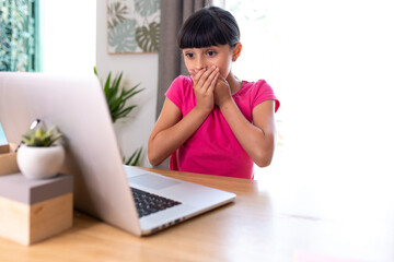 girl watching something surprising on a computer at home