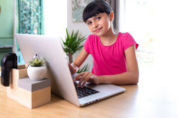 girl at home on a computer and attending a virtual class