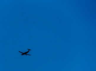 Plane flying to no where in bright blue sky with no clouds background great for text photograph