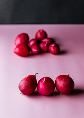 three radishes on a pink background and a bunch of radishes in the background