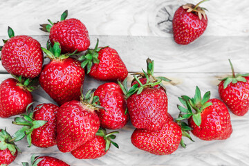 Berries of ripe juicy strawberries on a wooden background. A lot of strawberries lies on wooden boards. Free space on the image.