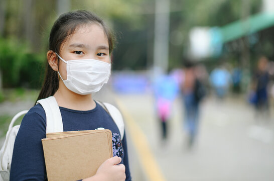 Back To School. Asian Child Girl Wearing Face Mask With Backpack  Going To School .Covid-19 Coronavirus Pandemic.New Normal Lifestyle.Education Concept.