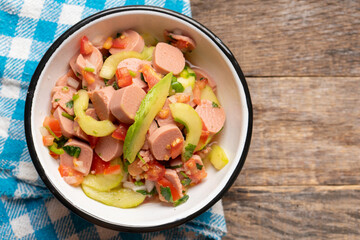 Mexican sausage ceviche with avocado on wooden background