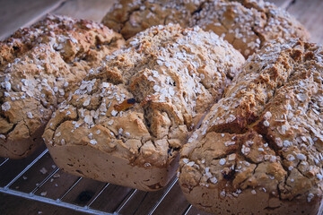 Gluten free rustic brown loaves of bread cooling on a tray