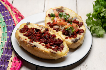 Traditional mexican molletes with chorizo and fresh sauce on white background