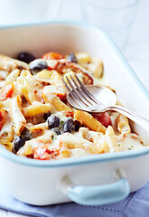 Penne Pasta with Vegetables and fresh Basil on bright wooden Background. Close up.