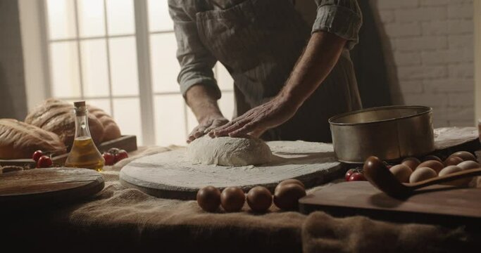 Professional senior moustached caucasian baker forming a bread loaf out of dough with passion, elderly pensioneer enjoying his hobby after retirement 4k footage