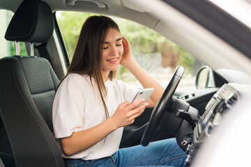 Young woman aending messages from phone while driving