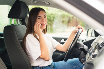 Attractive woman talk smart phone while driving. Beautiful woman driver talking on the phone.