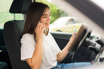 Attractive woman talk smart phone while driving. Beautiful woman driver talking on the phone.