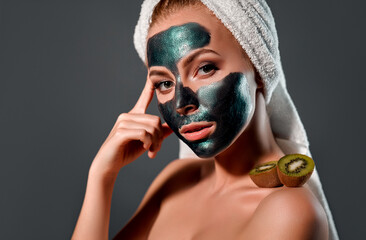 Beautiful woman with green peel-off mask on a gray background.