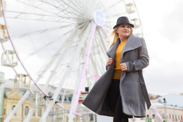 Stylish woman posing near ferris wheel