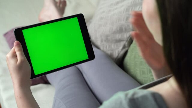 Young woman having green screen video call via tablet talking to someone. Friends, facetime, online, internet, long distance communication, chatting concept. skype chatting with grandmother.