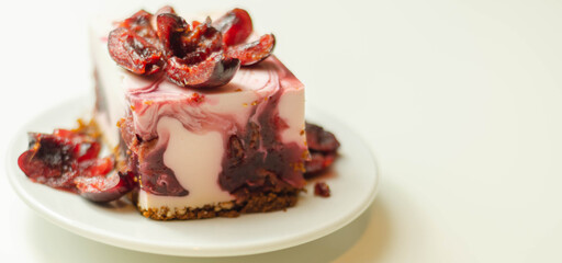 Japanese cheesecake with cherry sauce and fresh cherries on the ceramic plate and red background
