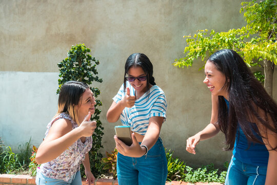 Three Beautiful Friends Sharing Things On Social Media On Their Smartphone