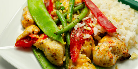 Chicken breast pieces in a Thai red curry sauce made with coconut cream, red chillies, lemongrass, lime leaf, with fragrant rice, red peppers, mange tout, and green beans