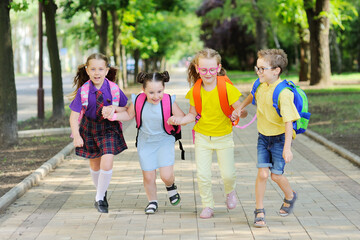 small schoolchildren with colorful school bags and backpacks run to school. Back to school, education, elementary school.