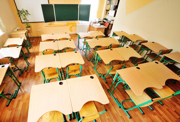 an empty schoolroom, desks, chairs, a green blackboard. The concept of back to school, no people, education.