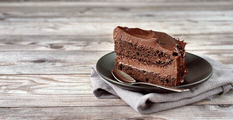 A peace of vegan chocolate davil cake on grey wooden background