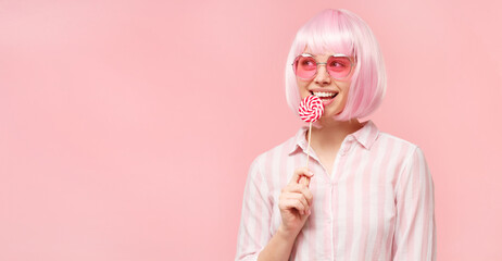 Horizontal banner of funny teenage girl in colored wig and eyeglasses, holding red and white...