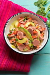 Mexican sausage ceviche with avocado on turquoise background