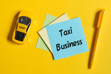 The concept of a taxi as a business. Toy car on a yellow background with a sticker. Top view.