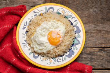 Fried egg with rice on wooden background