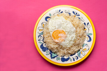 Fried egg with rice on pink background