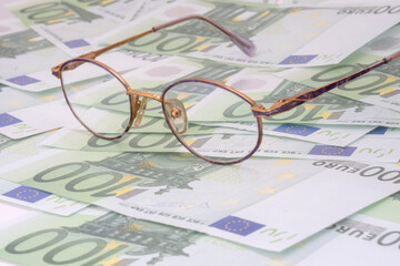 Children glasses against green euro banknotes. Economy through children eyes concept.