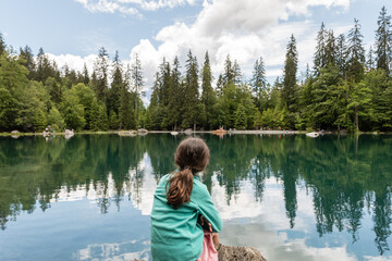 Fototapeta na wymiar Petite fille regardant le lac vert en haute savoie