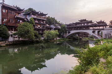 Old bridge reflecting in a river in Furong Zhen town, Hunan province, China