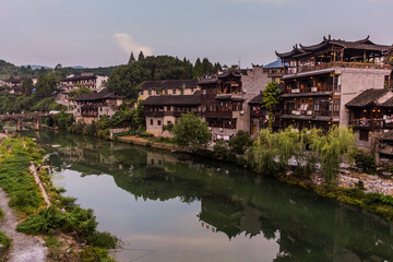 Fototapeta na wymiar Houses reflecting in a river in Furong Zhen town, Hunan province, China