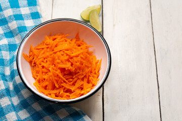 Grated carrot with lime and salt on white background