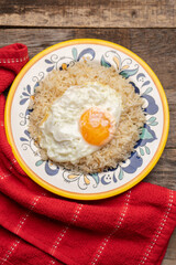 Fried egg with rice on wooden background