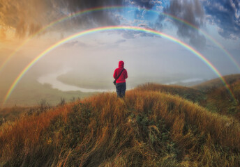 Fototapeta na wymiar Woman Looking At Rainbow. rainbow over the autumn river