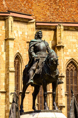 Fototapeta premium Statue of Matthias Corvinus, St. Michael's Church, a Gothic-style Roman Catholic church in Cluj-Napoca, Romania