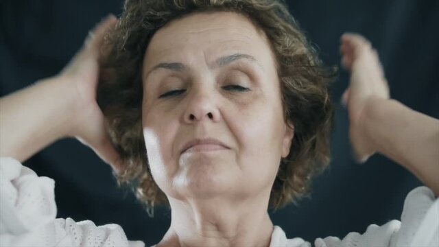 Beauty old senior woman is combing her hair. Happy elderly female concept.
